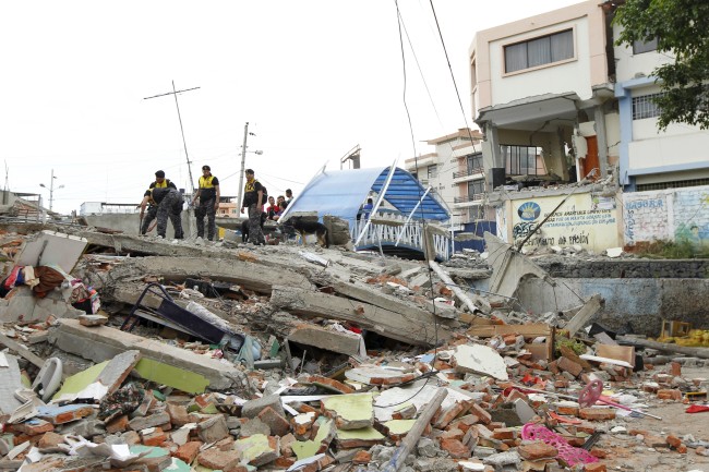 Police officers stand on debris after an earthquake struck off Ecuador's Pacific coast, at Tarqui neighborhood in Manta April 17, 2016.  REUTERS/Guillermo Granja